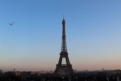 Silhouette eiffel tower in city against clear sky during sunset
