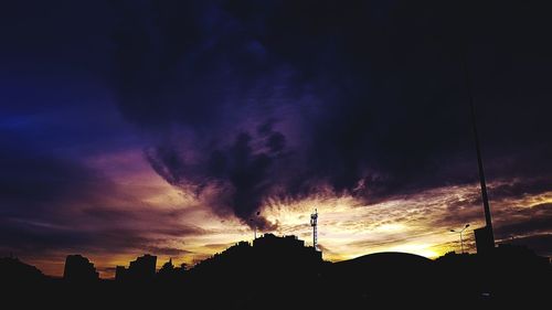 Low angle view of silhouette buildings against dramatic sky