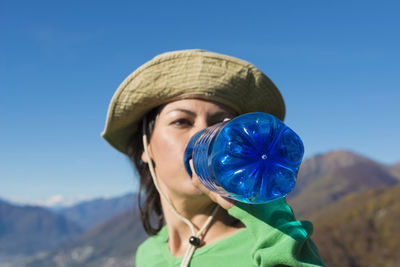 Close-up of young woman against clear blue sky