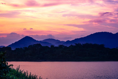 Silhouette mountain with attractive background, sunset with vivid purple sky and lake