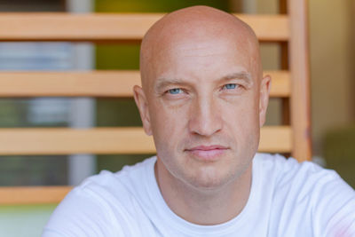 Portrait handsome bald man with blue eyes in a white t-shirt with a pensive