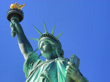 Low angle view of statue against blue sky