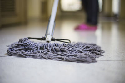 Low section of person cleaning floor with mop