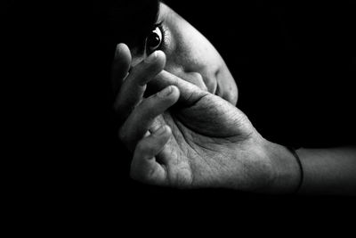 Close-up of woman hand over black background