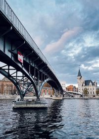 Bridge over river against buildings in city