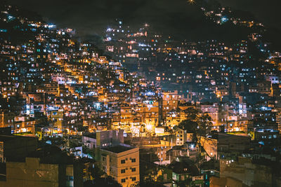 Illuminated cityscape against sky at night