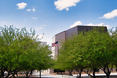 Low angle view of trees and buildings against sky