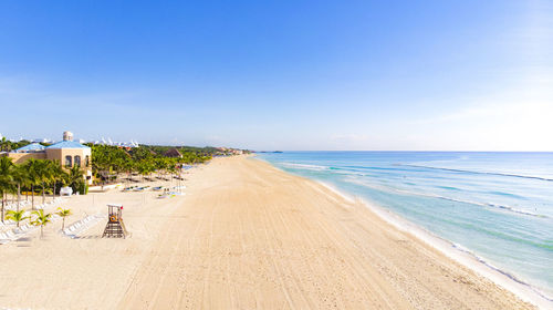 Scenic view of beach against clear blue sky