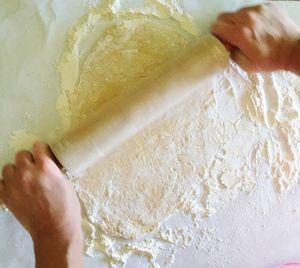 Cropped image of woman rolling out dough at home