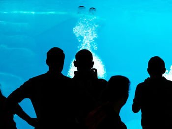 Silhouette people swimming in pool