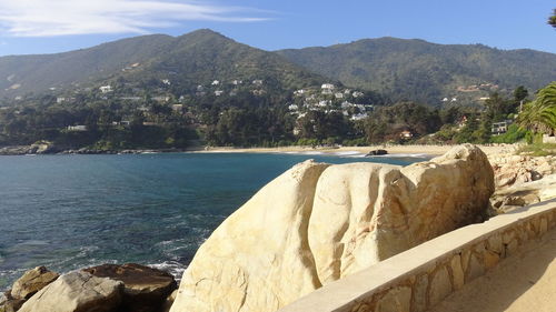 Rocks by sea against sky