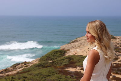 Young woman on beach against sky