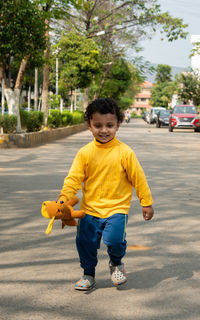 Portrait of cute boy standing on road