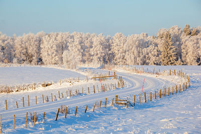 Scenic view of snow covered field against sky