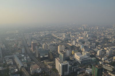 Aerial view of buildings in city against sky