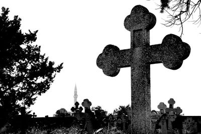 Low angle view of silhouette cross against sky