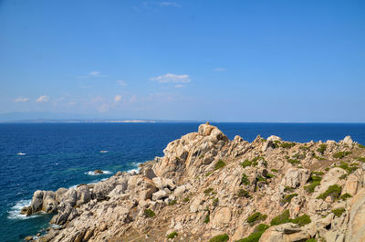 Scenic view of rocks on beach against sky