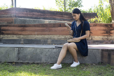 Full length of woman sitting on staircase