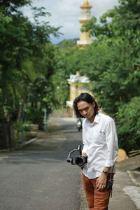 Full length of man photographing while standing on tree