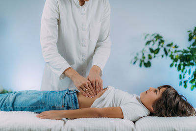 Midsection of doctor examining patient in hospital