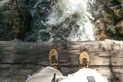 Low section of man standing by water