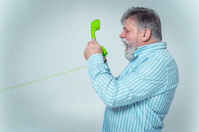 Side view of a man drinking water against white background