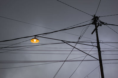 Low angle view of illuminated street light against sky