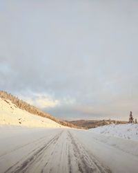 Snow covered landscape against sky