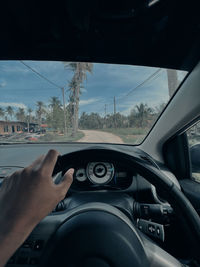Cropped hand of man driving car