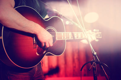 Midsection of man playing guitar