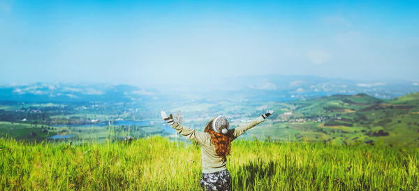 Rear view of woman standing on field