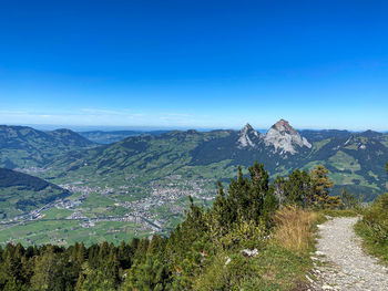 Scenic view of mountains against blue sky