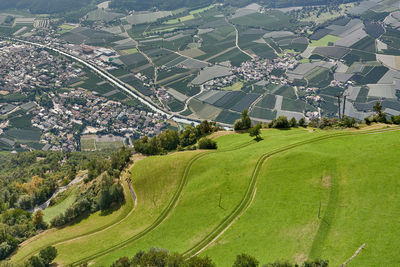 High angle view of agricultural field by buildings in city