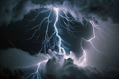 Low angle view of lightnings  between clouds at night