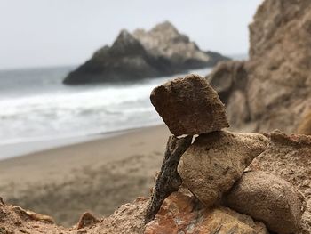 Close-up of rocks on beach against sky