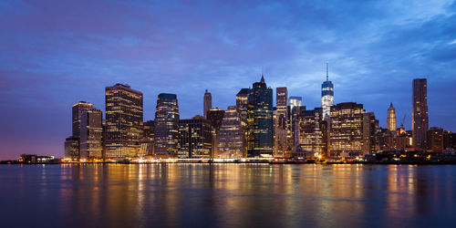 Illuminated buildings in city at dusk