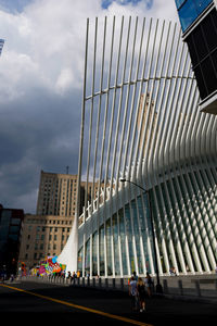 People walking on street against modern buildings in city