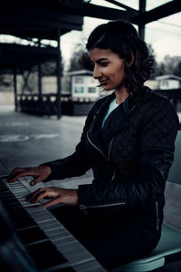 Side view of woman using piano 