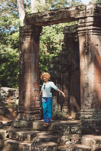 Full length of woman standing by historic building