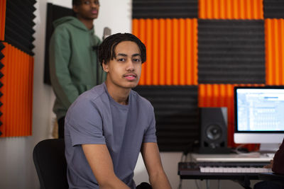 Portrait of boy wearing t-shirt sitting in recording studio