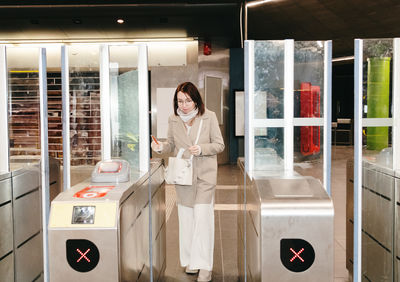 Portrait of a pensive girl exiting the metro through a turnstile.