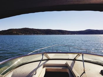 Boat sailing on sea against clear sky