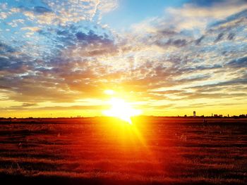 Scenic view of silhouette field against sky at sunset