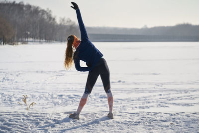 Woman stretching on snow