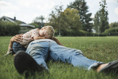 Rear view of father and son on field