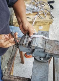 Midsection of man working on metal