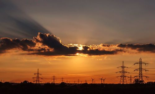 Silhouette landscape against dramatic sky during sunset