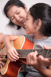 Mother and daughter playing guitar