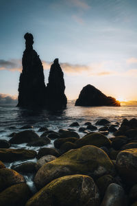 Waves over a rocky shoreline with sea stacks at sunrise