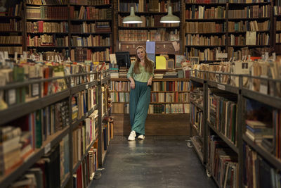 Young woman leaning on table at library